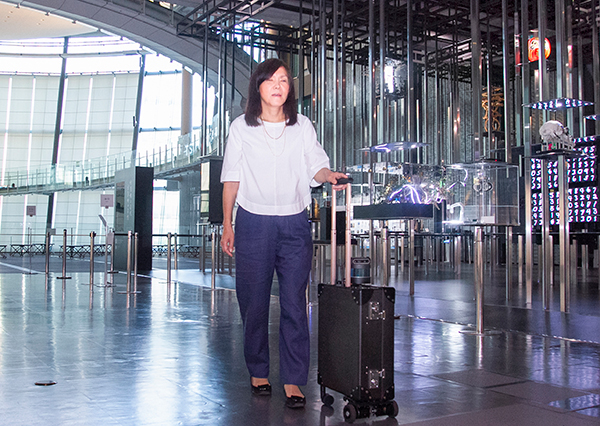 近代的な施設の中で浅川智恵子先端研フェローがAIスーツケースに誘導されています。