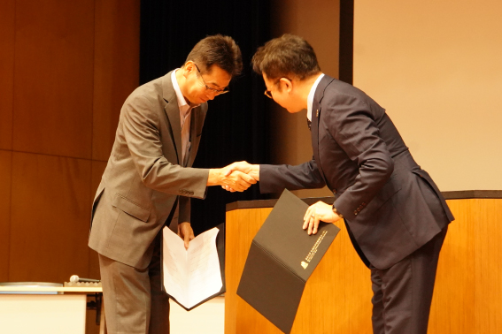 握手を交わす先端研 稲見昌彦副所⻑(右)と復興庁 宇野善昌統括官(左)